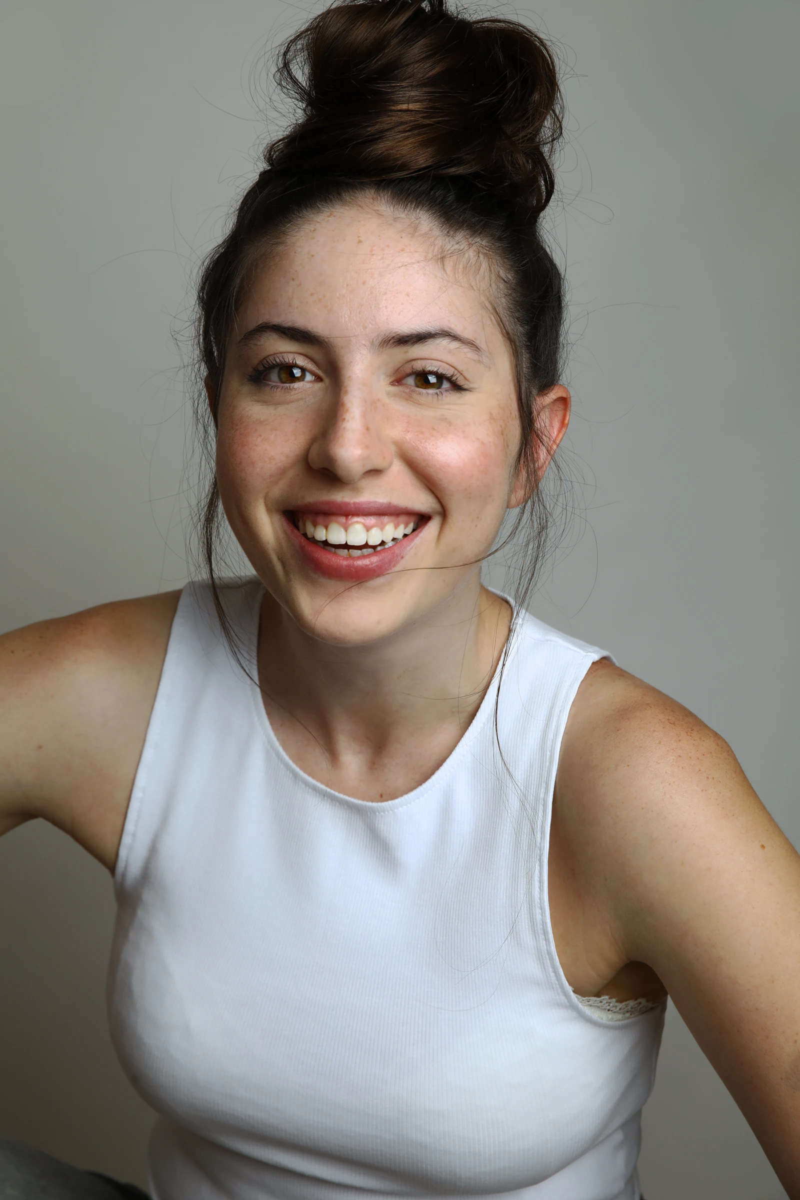 Yuli Vantura smiling in a white tank top with her hair up